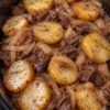 Slow cooker beef and potatoes with tender chuck, golden potato rounds, onions, and brown gravy