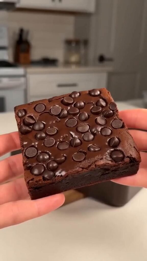 Fudgy sweet potato brownie topped with dark chocolate chips, showing its dense chocolate center
